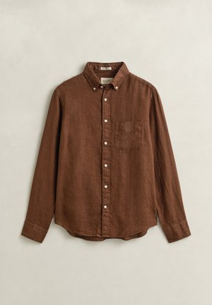 Bruin linnen overhemd met lange mouwen, een button-down kraag, witte knopen en een borstzak, plat neergelegd op een neutrale achtergrond.