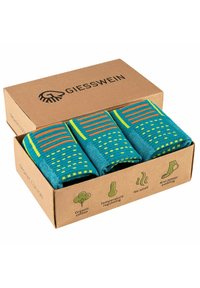 Three pairs of turquoise socks in a cardboard box, featuring striped and dotted patterns, made from organic cotton with anti-blister padding.