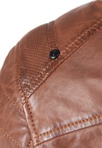 Braune Lederkappe mit glatter Textur, gesteppten Akzenten und einem schwarzen Knopfdetail. Enthält Perforationen zur Belüftung.