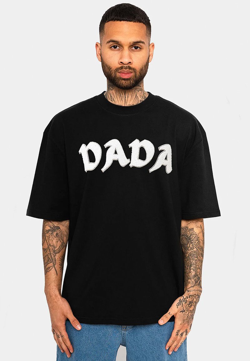 Schwarzes Baumwoll-T-Shirt mit oversized Schnitt, runder Halsöffnung und weißem "DADA"-Text, kurzen Ärmeln und einem lässigen Design.