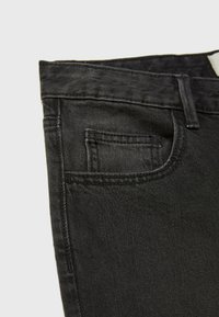 Schwarze Denim-Jeans im Slim-Fit-Schnitt, mit einer kleinen Fronttasche, Gürtelschlaufen und einem normalen Bund. Glatte Textur und robuste Nähte.