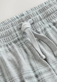 Šedé kárované šortky s elastickým pásom a predným šnurovaním. Tkanina je jemná, s decentným vzorom a voľným strihom.