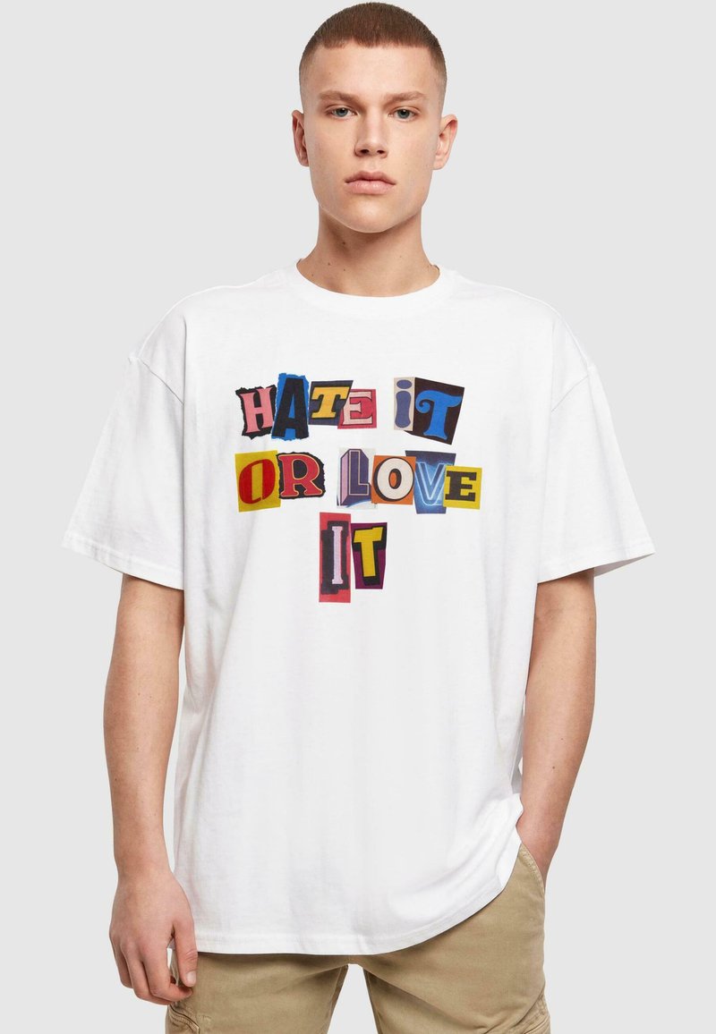 Hvid bomulds t-shirt med et dristigt grafik, der viser teksten "HATE IT OR LOVE IT" i farverige, mixt typer og former.