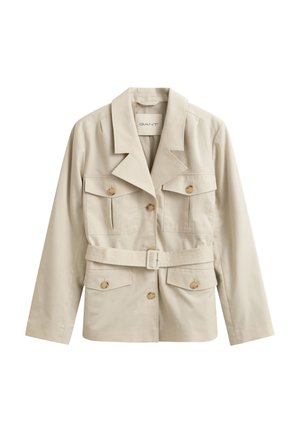 Beige Jacke mit Gürtel, breiten Revers, vier geknöpften Klappentaschen und Knopfverschluss vorne, auf weißem Hintergrund dargestellt.