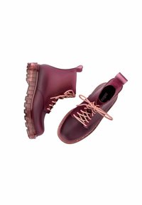Botas de tobillo de goma burdeos translúcidas con una suela gruesa y transparente, que presentan cordones rosa claro y una pestaña en el talón.