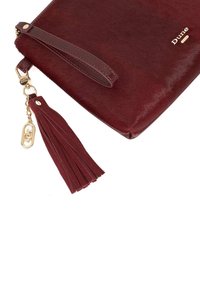 Burgundy leather clutch with a smooth finish, featuring a gold-tone zipper, a tassel accent, and embossed logo detail.