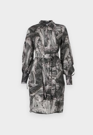 Vestido de patrón blanco y negro con escote de piel, mangas largas, cierre de botones en la parte delantera y un cinturón de lazo en la cintura. Tela transparente.