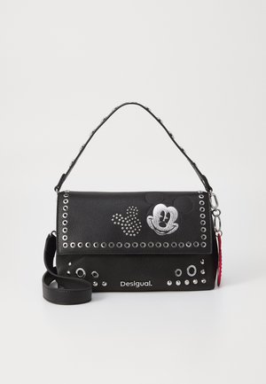 Bolso negro Desigual con tachuelas plateadas, diseño de cara y mano de Mickey Mouse, asa corta y correa de hombro desmontable sobre fondo blanco.