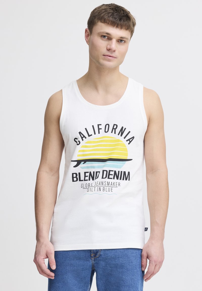 Tricou fără mâneci din bumbac alb, prezentând o grafică colorată cu un soare și dungi, etichetat "California Blend Denim" cu text bold negru.