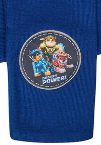 Calzini blu in tessuto lavorato a maglia con una toppa circolare che raffigura cani dei cartoni animati in costumi da supereroe e il testo "Mighty Power!" in bianco.