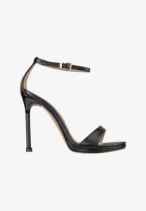 Sandalo nero con tacco alto, sottile cinturino alla caviglia, punta aperta e tacco a stiletto, mostrato di profilo su sfondo bianco.