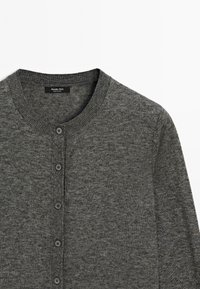 Cardigan en laine grise avec un col rond, comportant cinq boutons sur le devant et l'étiquette de la marque Massimo Dutti à l'intérieur du col.