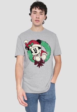 Gray cotton t-shirt featuring a green wreath design, with a cartoon character wearing a red Santa hat and suit. Distressed texture details visible.