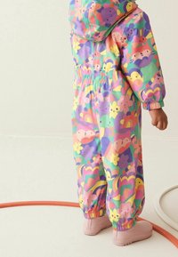 Kolorowy, wodoodporny kombinezon z żywym wzorem cartoon przedstawiającym zwierzęta i kwiaty. Posiada elastyczne mankiety i pas; zapinany na kaptur.