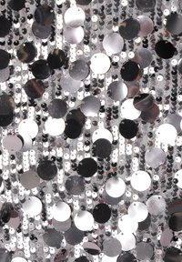 Tessuto argento e nero con paillettes che combina sequins circolari lucidi e piccoli dischi piatti di varie dimensioni, creando un aspetto strutturato.
