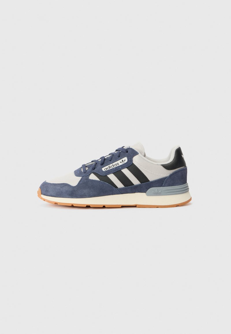 Tenis navy din suede și textil gri, cu dungi negre, logo alb și talpă de cauciuc bej. Dispune de șirete rotunde și guler căptușit.