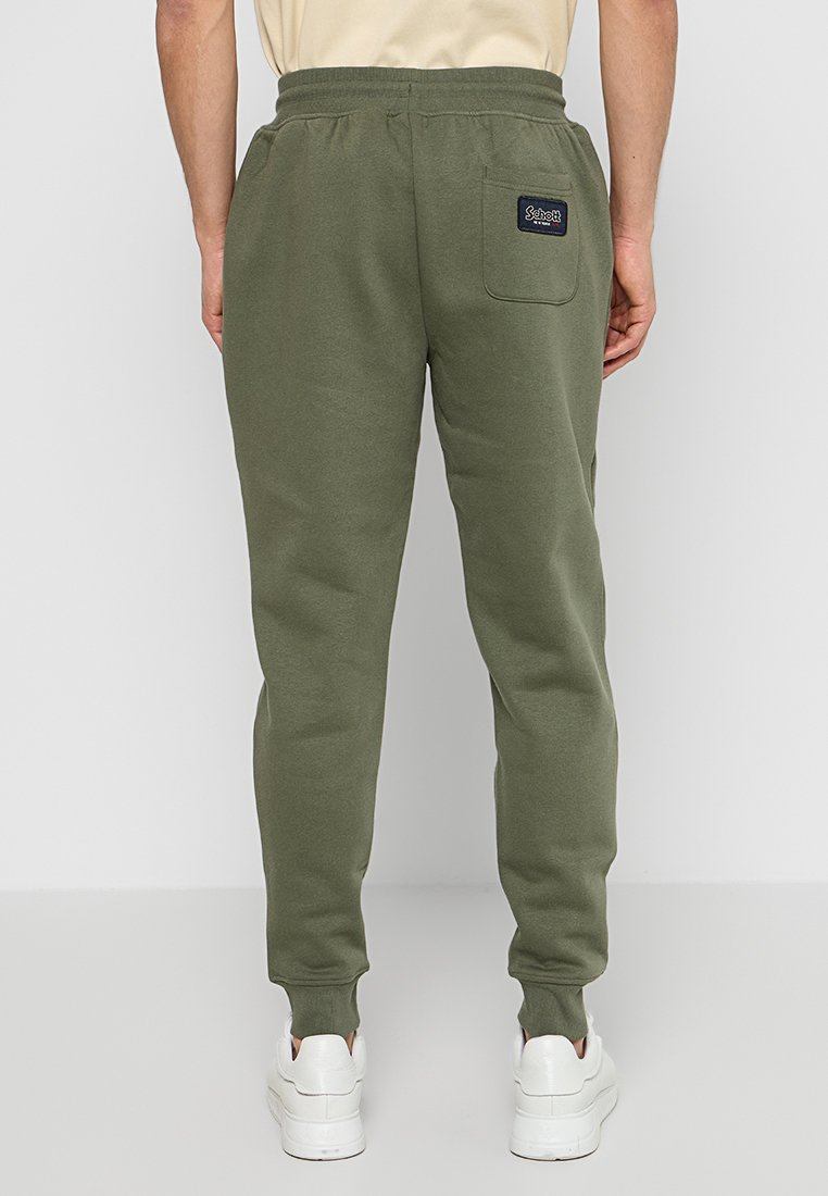Pantaloni da jogging verde oliva realizzati in materiale morbido, caratterizzati da una vestibilità affusolata, vita elastica e una tasca posteriore con una patch del logo.