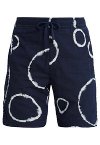 Námořnické modré plavky vyrobené z lnu s bílým kruhovým tie-dye vzorem, s elastickým pasem a stahovací šňůrkou.