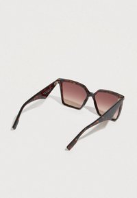 Gafas de sol con montura cuadrada de carey, lentes marrones degradados y varillas elegantes con un detalle metálico en la bisagra.