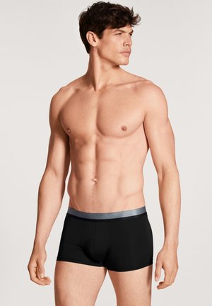 Boxer da uomo neri con elastico argento in vita, caratterizzati da una texture liscia e un design aderente per comfort e supporto.