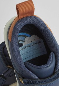 Marineblaue Kindersneaker mit einem strukturierten Obermaterial aus Leder und Mesh. Verfügt über einen Akzent aus braunem Wildleder und ein buntes Wolkengrafik auf der Innensohle.