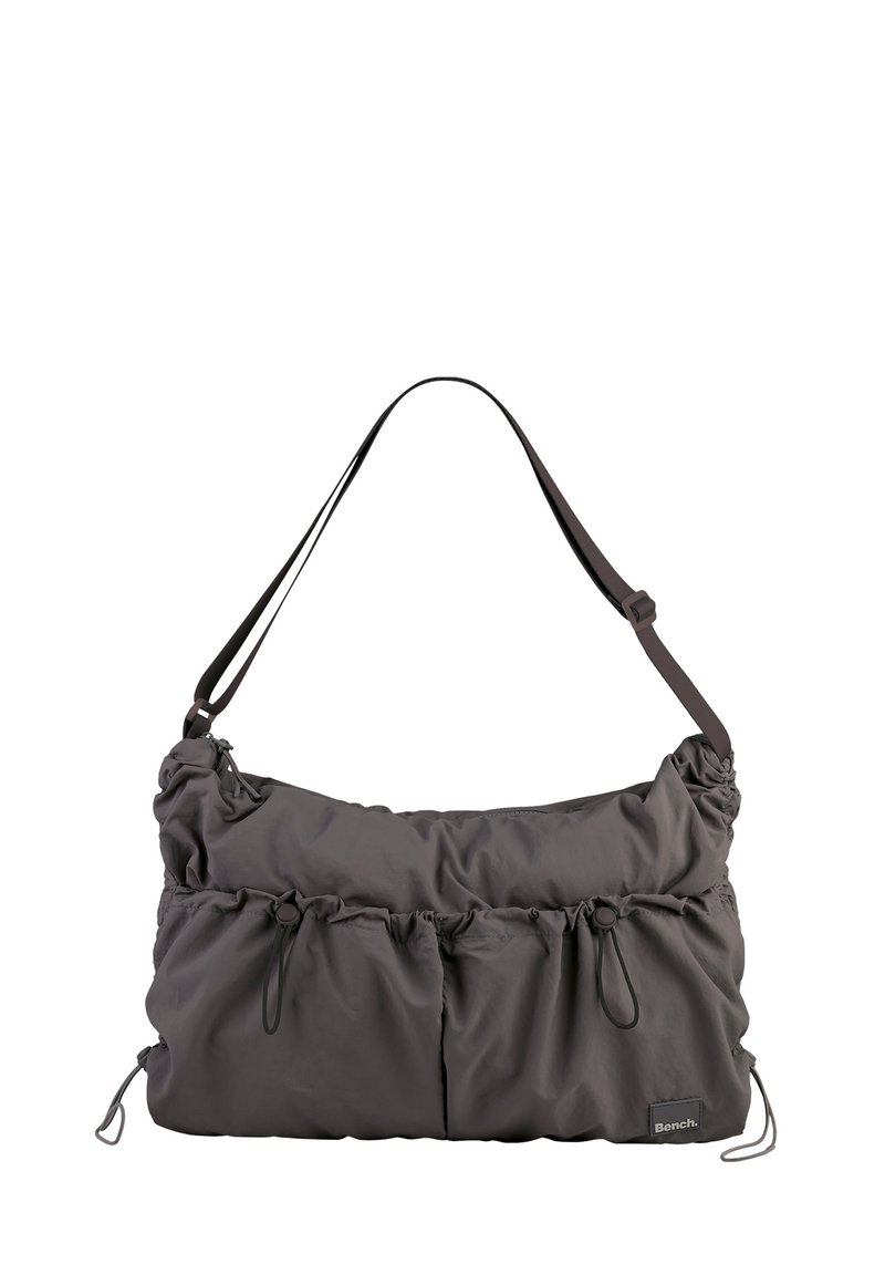 Gray, soft-shell bag with a gathered texture, adjustable strap, and cinching details. Features a subtle logo patch.