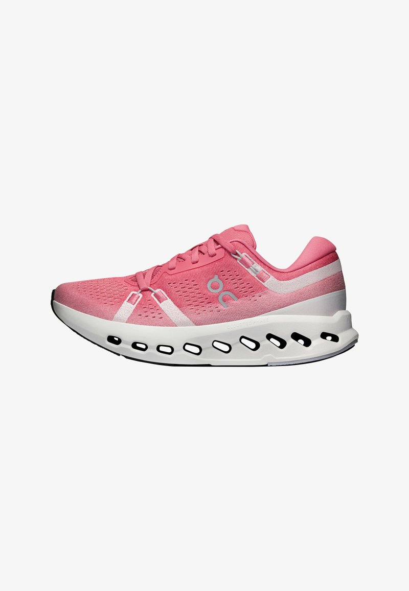 Baskets de sport roses avec semelle blanche rembourrée présentant des découpes ovales noires et un logo latéral, conçues pour la course ou un usage décontracté.