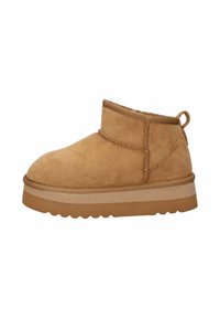 Stivaletto in suede beige con suola in gomma spessa e linguetta sul tallone, progettato per un uso casual e invernale.