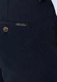 Marineblauwe katoenen broek met een voorzak met een bruine knoop en een klein gouden "Brooks Brothers" label. Soepele textuur met eenTAILORED ontwerp.