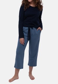 Marinblå långärmad topp som är kombinerad med ljusblå korta byxor med elastisk midja som har snörning och sidofickor, tillverkade av mjukt tyg.