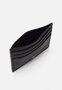 Portafoglio in pelle nera con più scomparti per carte, profilo sottile e finitura testurizzata. Caratteristiche di un raffinato dettaglio hardware.
