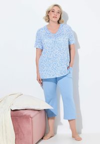 Conjunto de pijama azul claro que incluye una parte superior floral de manga corta con escote en V y pantalones capri a juego. Tejido de algodón suave con un corte holgado.