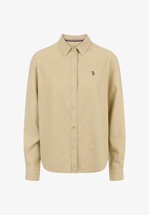 Beige langærmet skjorte med knappet krave, med et lille broderet motiv på venstre bryst og glat bomuldstekstur.