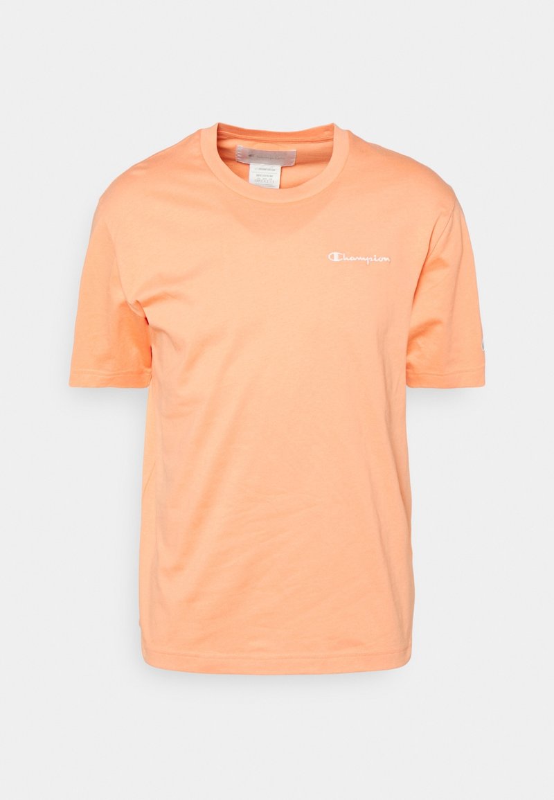 Kortärmad t-shirt med rund halsringning i ljus persikofärg, tillverkad av bomull, med en liten vit logotyp på bröstet och slät textur.