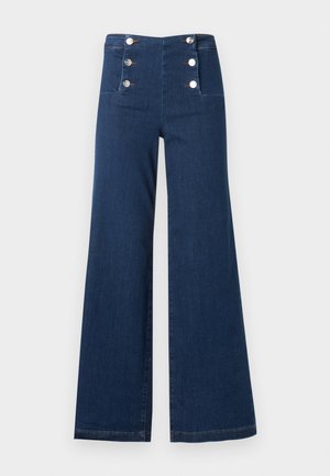 Dunkelblaue Jeans mit weitem Bein und hoher Taille, vorne am Bund mit sechs silbernen Knöpfen in zwei senkrechten Reihen angeordnet.