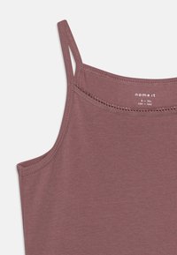 Un top senza maniche color mauve realizzato in morbido cotone, con spalline sottili e un delicato bordo cucito lungo il collo.