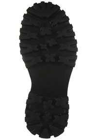 Suela de goma negra con patrones de profundidad en la suela, que combina clavos en ángulo y en forma de cruz para una mejor agarre y tracción.