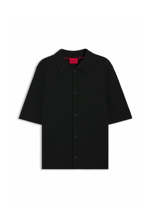 Schwarzes Kurzarmhemd aus geripptem Stoff, mit durchgehender Knopfleiste und klassischem Kragen. Das Innenetikett ist leuchtend rot.