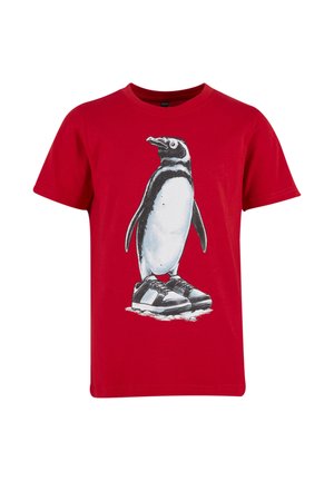 Camiseta roja de manga corta con un gráfico de un pingüino que lleva zapatillas blancas y negras, de pie sobre hielo.