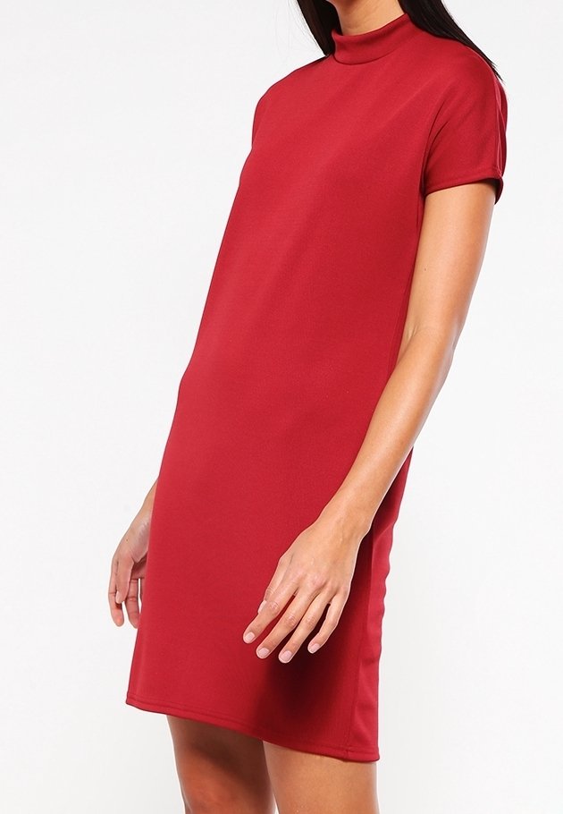 Femme portant une robe rouge unie à manches courtes avec un col montant, montrée de la mi-cuisse au cou sur fond blanc.