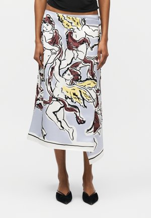 Gonna midi con base bianca che presenta cherubini astratti con ali gialle e drappeggi rossi, indossata con décolleté nere con punta appuntita.