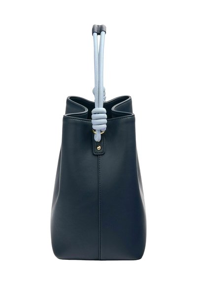Dark navy leather bucket bag with a soft textured finish, featuring a light blue rope handle and gold-tone hardware detail at the base.