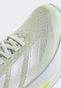 Lichtgroene, gestructureerde sportschoen met een bovenwerk van mesh, versterkte accenten en opvallende witte branding met drie strepen. Gevoerde zool met gele details.