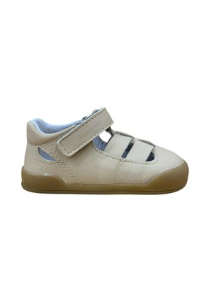 Sandalia infantil de cuero beige con tira ajustable de velcro, puntera cerrada y suela de goma marrón antideslizante.