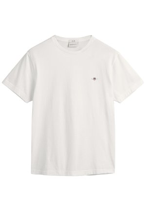 Biała bawełniana koszulka z okrągłym dekoltem i krótkimi rękawami, z małym haftowanym logo po lewej stronie klatki piersiowej. Gładka tekstura.