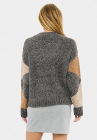 Strickpullover mit rundem Halsausschnitt, grauem Körper, strukturierten Ärmeln in beige und braunen Tönen sowie geripptem Saum und Bündchen.