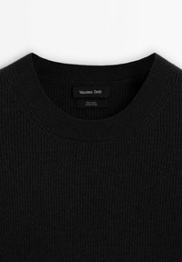 Ciemnoszary prążkowany sweter wełniany z okrągłym dekoltem. Metka zawiera nazwę marki, materiał i kraj produkcji. Tekstura wydaje się miękka.