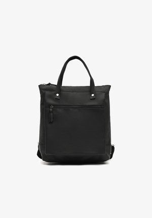 Bolso tote negro hecho de cuero y tela, con cierre de cremallera, dos asas cortas y un bolsillo frontal con detalles de cremallera.