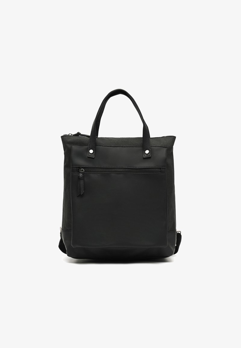 Svart toteväska i läder och tyg, med dragkedjestängning, två korta handtag och en frontficka med dragkedjedetalj.