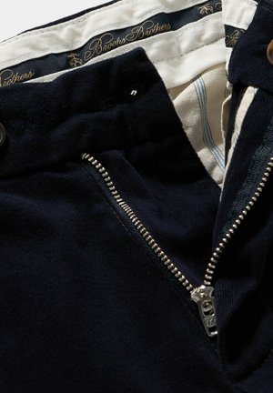 Dunkelblaue Cordhosen mit Reißverschluss und Knopfverschluss. Das Innenfutter hat eine einfarbige weiße Fütterung mit blauen Streifen.